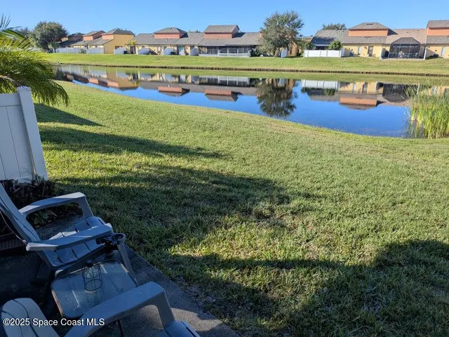 a kitchen with granite countertop a refrigerator a stove a sink and a dining table with wooden floor