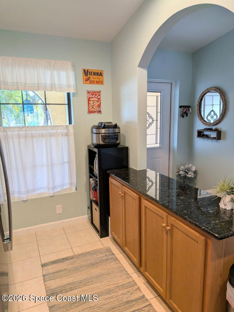 4530 Radiant Way, Unit 101 Melbourne, FL 32901 - Photo 19 of 26 a kitchen with granite countertop a refrigerator a stove a sink and a dining table with wooden floor