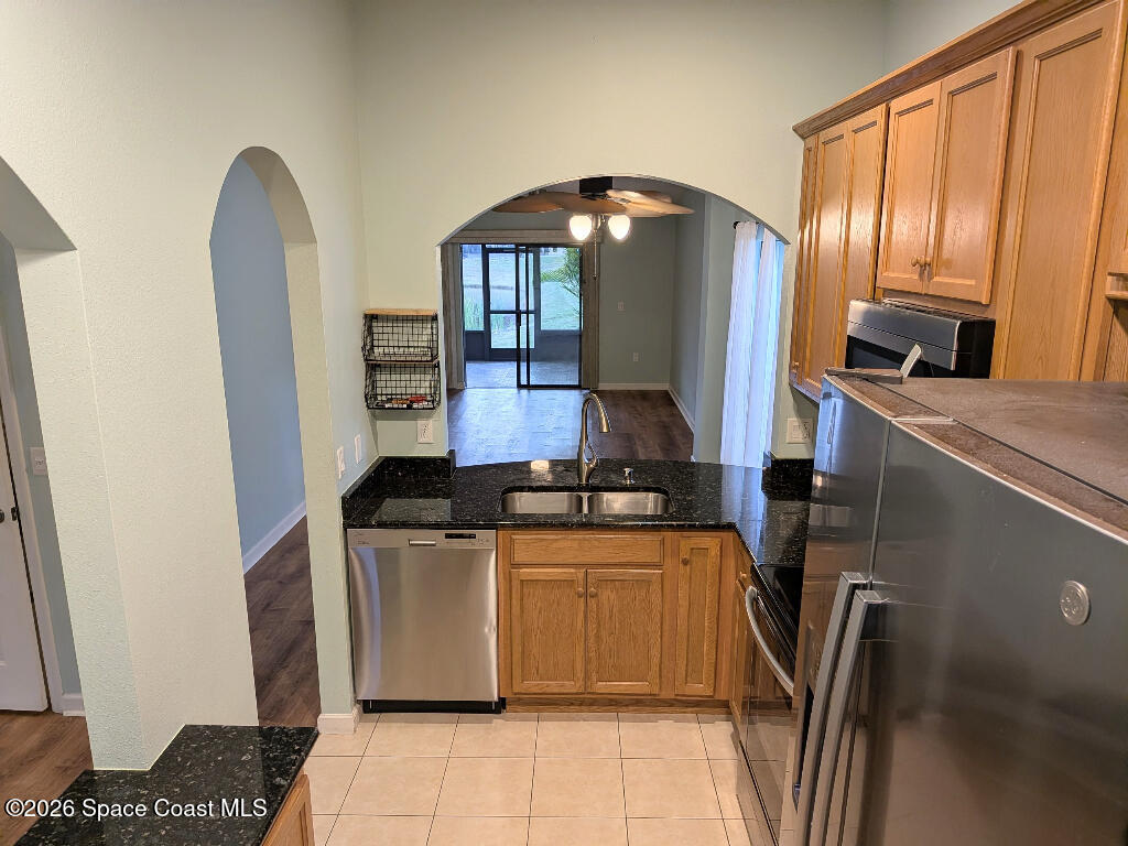 4530 Radiant Way, Unit 101 Melbourne, FL 32901 - Photo 25 of 26 a kitchen with stainless steel appliances granite countertop a sink a stove and a refrigerator