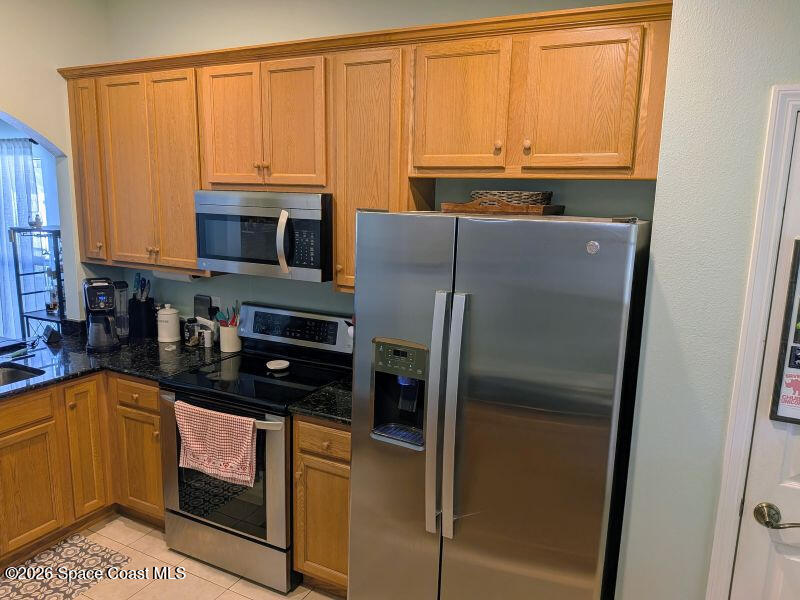 4530 Radiant Way, Unit 101 Melbourne, FL 32901 - Photo 4 of 26 a kitchen with a refrigerator a microwave a sink and cabinets
