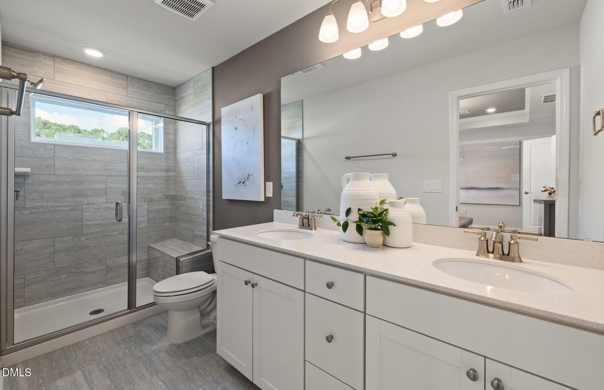 2544 Olive Chapel Road Apex, NC 27502 - Photo 12 of 32 a bathroom with a double vanity sink toilet and shower