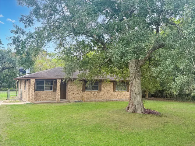 a front view of a house with a garden and tree