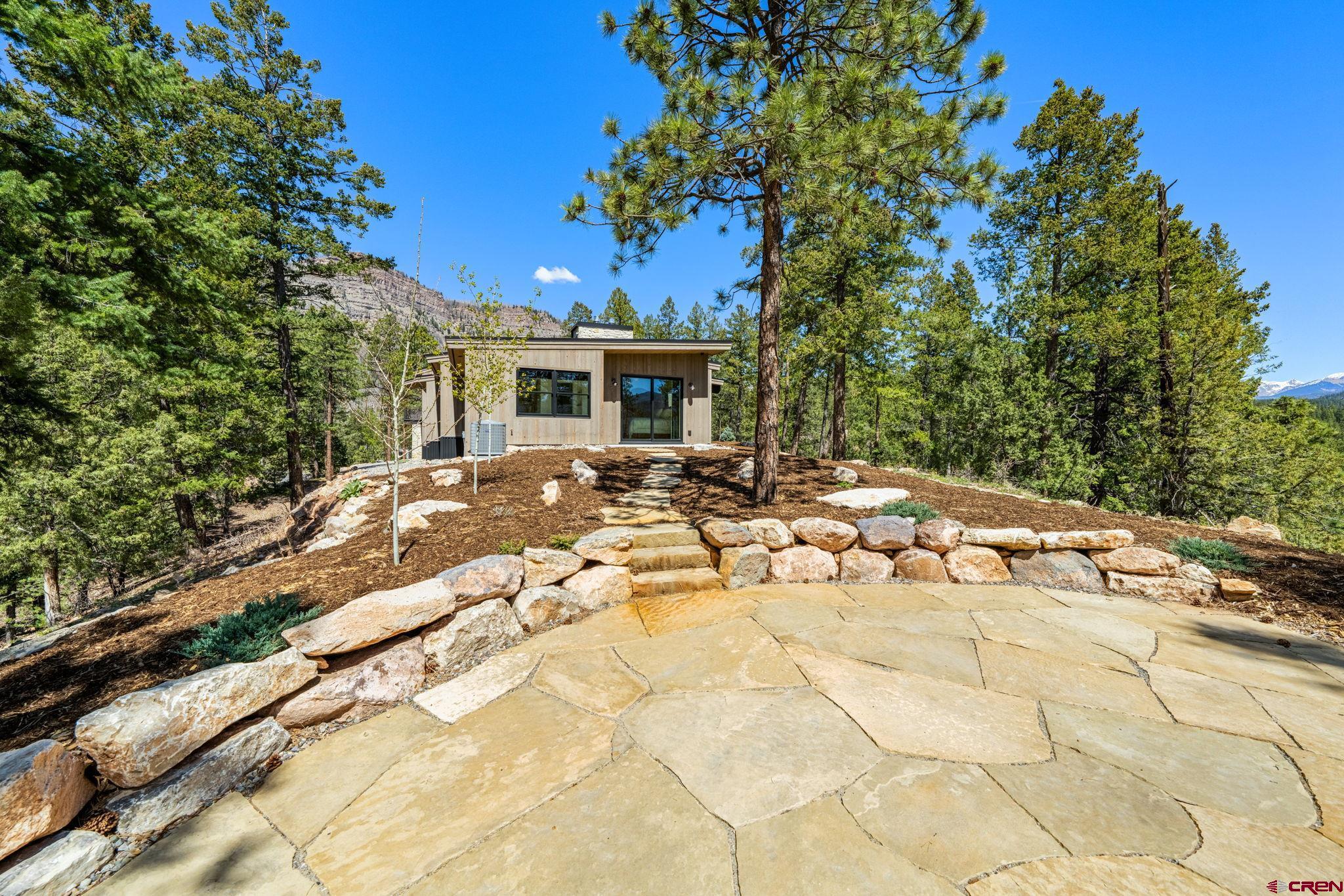 49 Bluff Drive Durango, CO 81301 - Photo 15 of 45 a view of a patio with table and chairs and potted plants with large trees