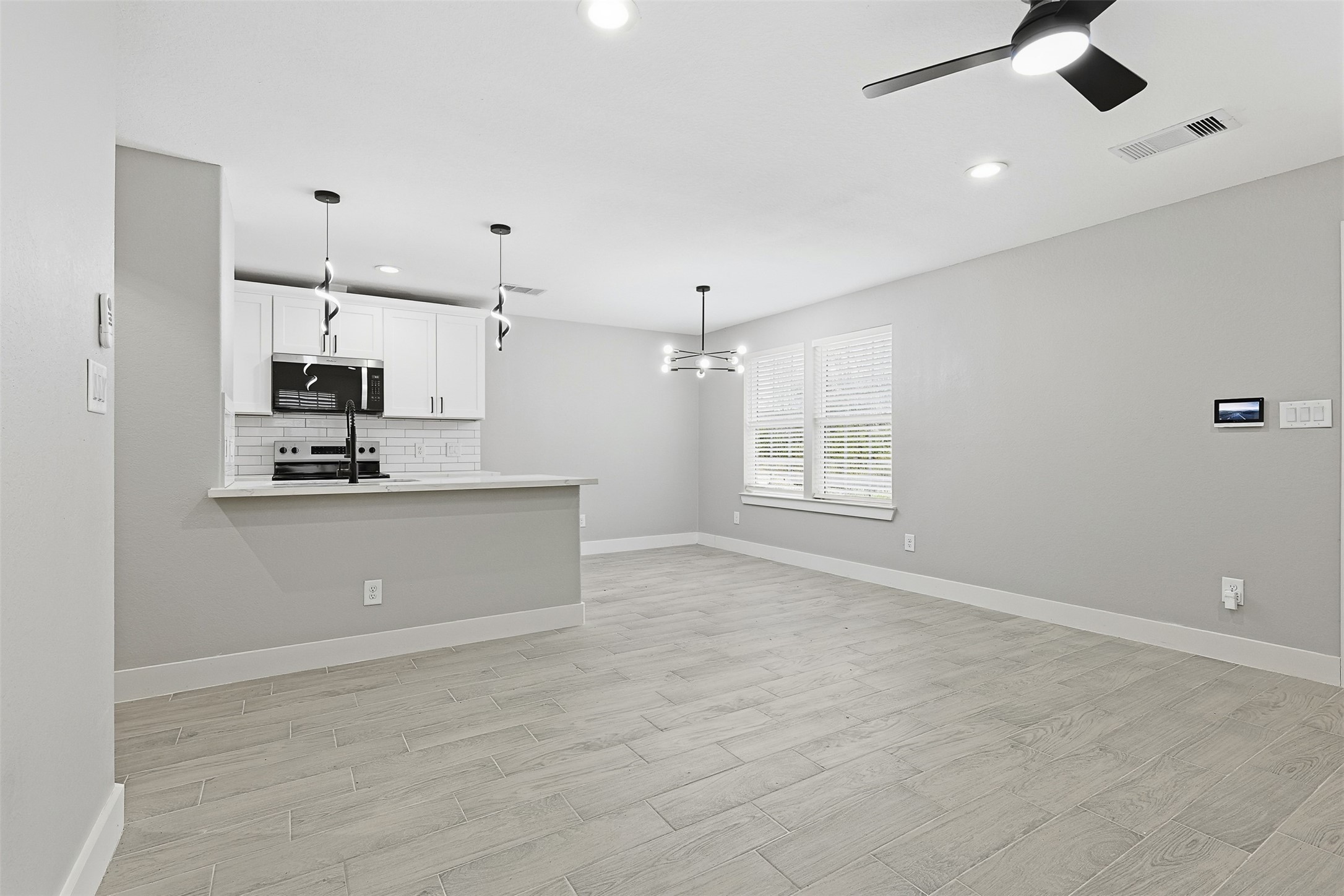 9718 Fillmore Street Houston, TX 77029 - Photo 12 of 30 a view of kitchen and empty room with ceiling fan
