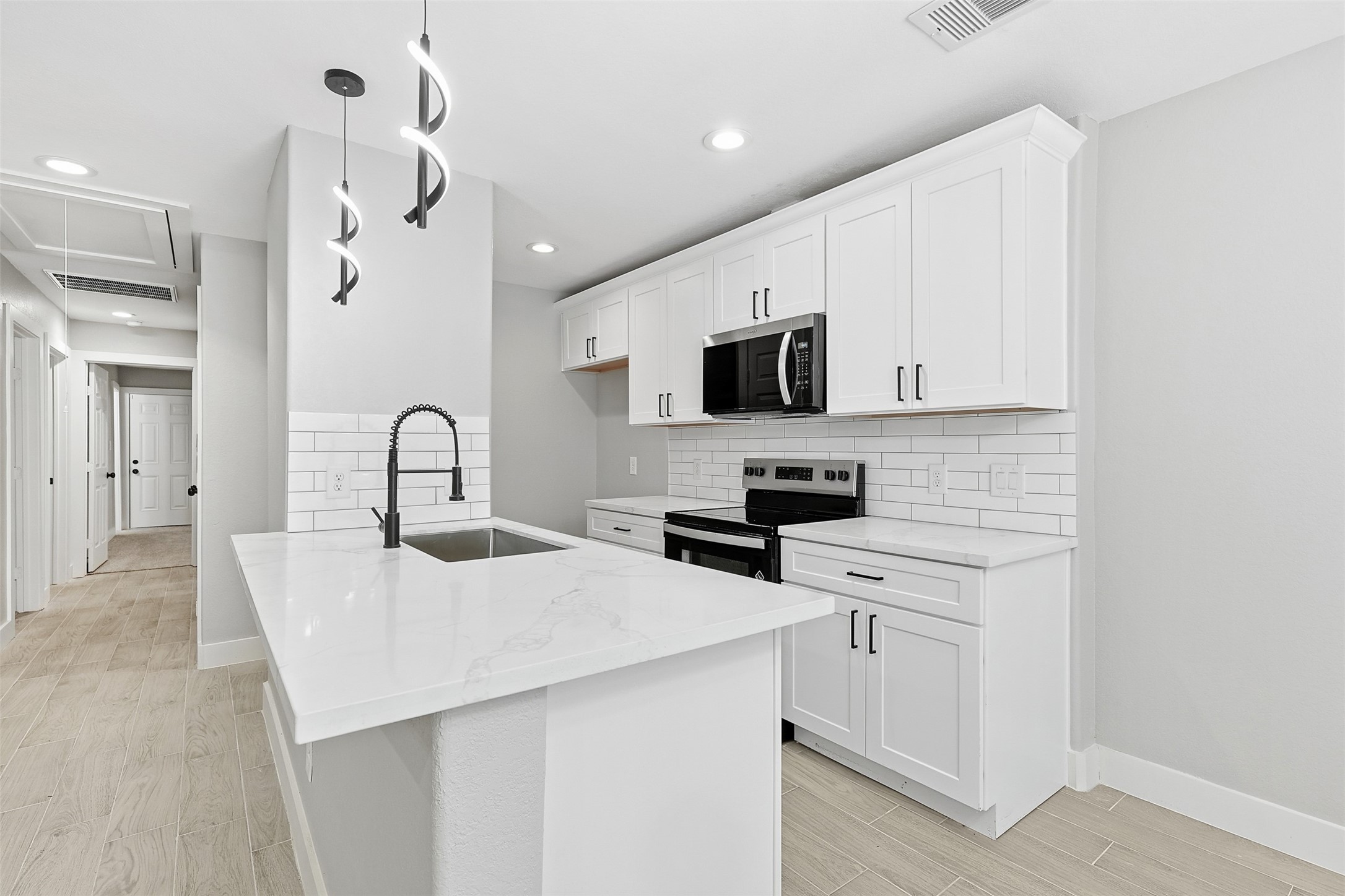 9718 Fillmore Street Houston, TX 77029 - Photo 8 of 30 a kitchen with stainless steel appliances a sink a stove a refrigerator cabinets and a dining table
