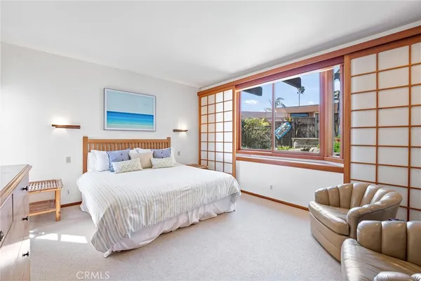 a bedroom with a bed and a large window