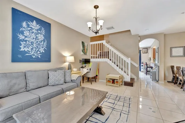 a living room with furniture a dining table and a chandelier