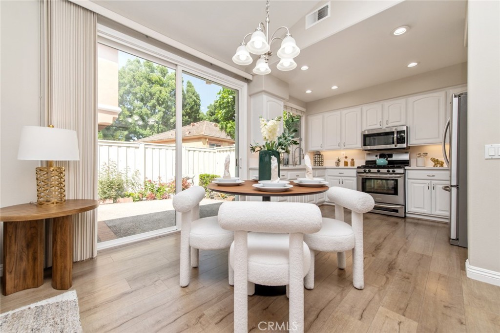 12 Parthenia Irvine, CA 92606 - Photo 7 of 25 a view of a dining room with furniture a chandelier and wooden floor