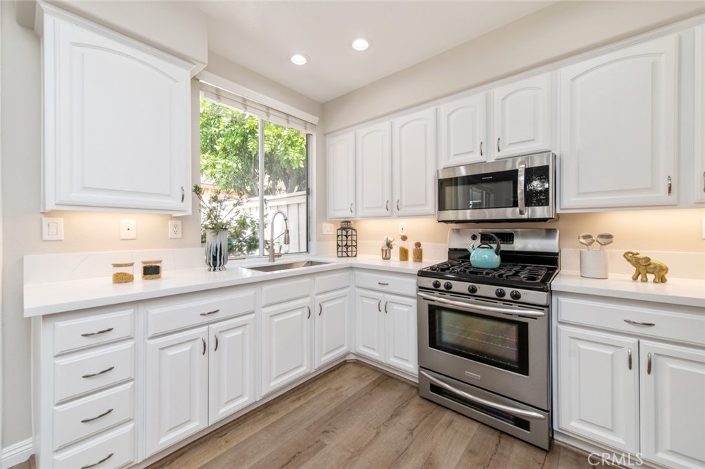 12 Parthenia Irvine, CA 92606 - Photo 9 of 25 a kitchen with granite countertop white cabinets appliances and a window
