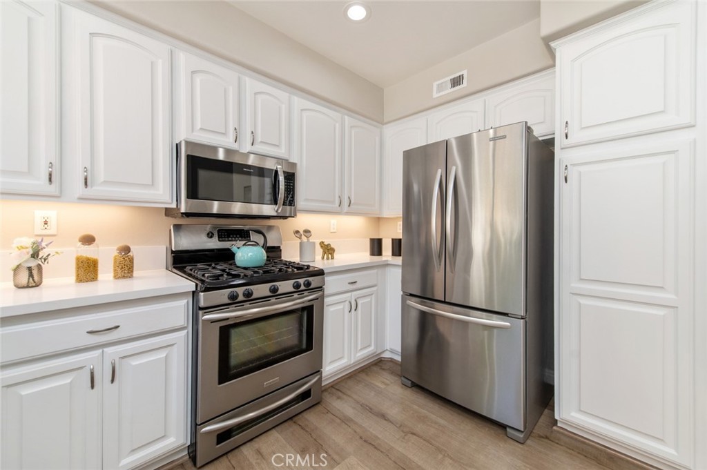 12 Parthenia Irvine, CA 92606 - Photo 10 of 25 a kitchen with cabinets stainless steel appliances and wooden floor