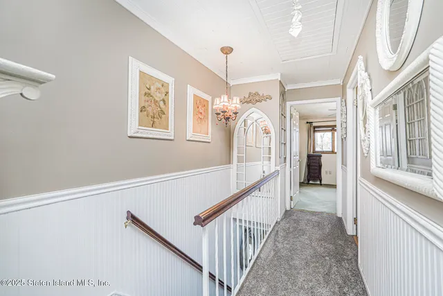 a bedroom with a bed a window and a chandelier