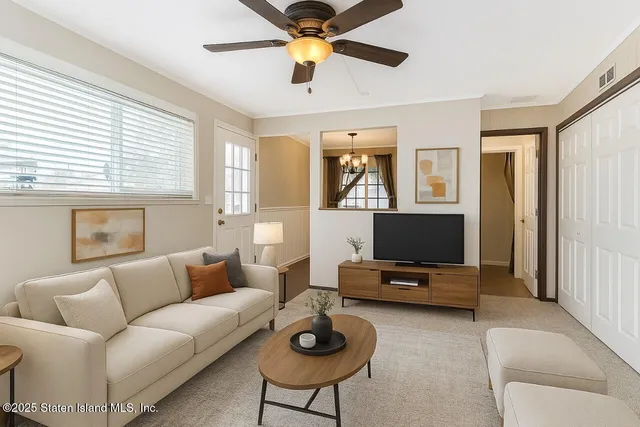 a living room with furniture a flat screen tv and a window
