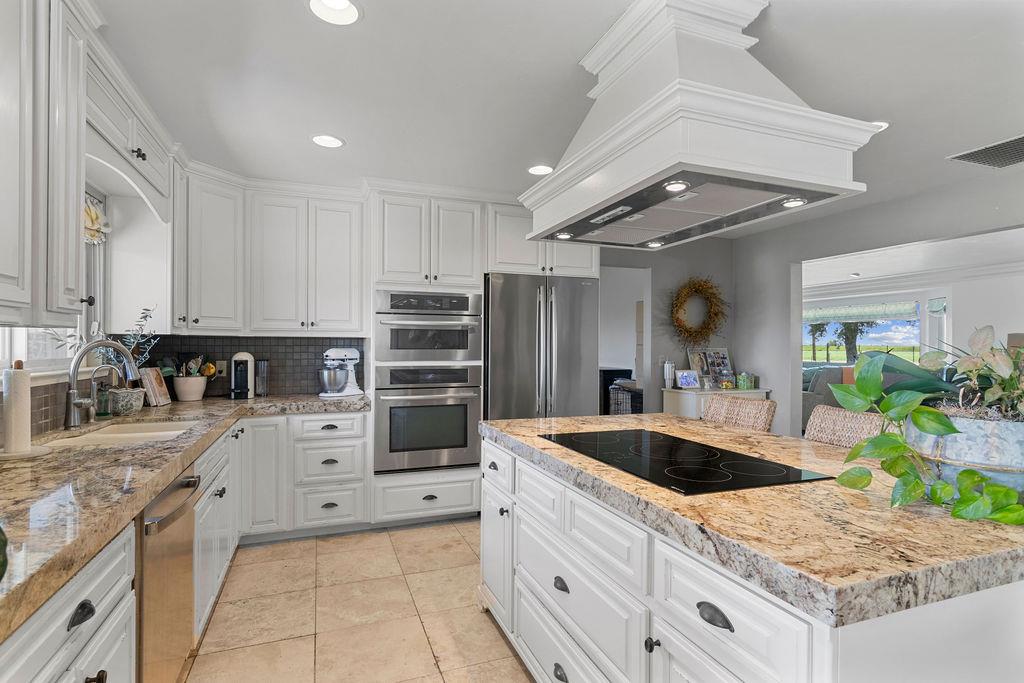 4930 South Faith Home Road Turlock, CA 95380 - Photo 11 of 69 kitchen with white cabinets, Jenn-Air stainless steel appliances, backsplash, light stone counters, and recessed lighting