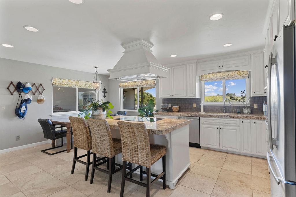 4930 South Faith Home Road Turlock, CA 95380 - Photo 12 of 69 kitchen featuring a breakfast bar area, white cabinetry, stainless steel appliances, and a kitchen island