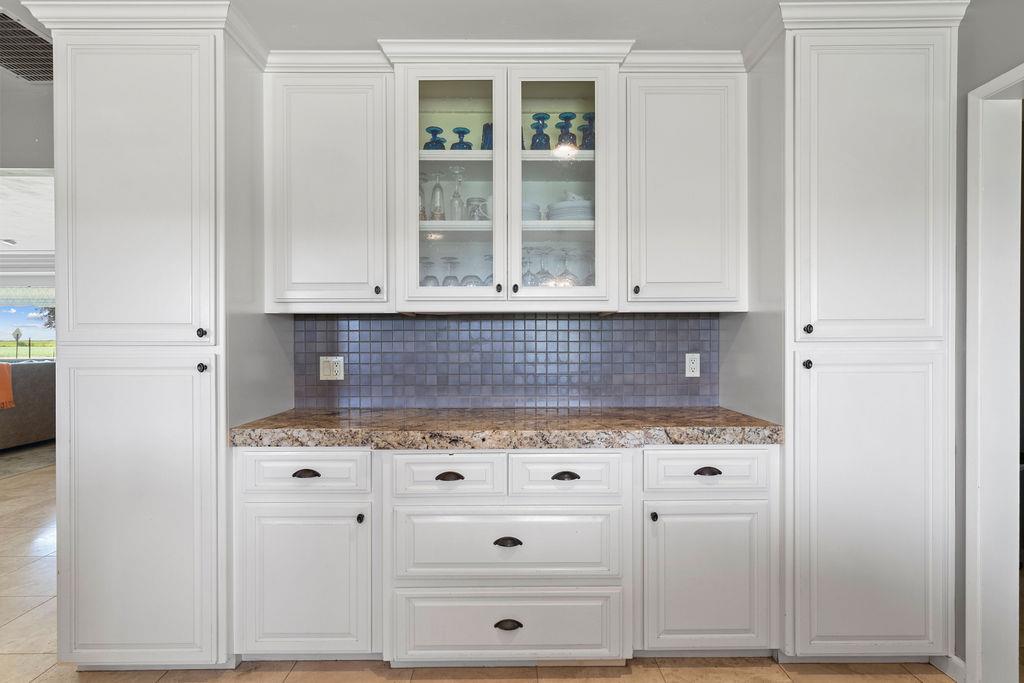4930 South Faith Home Road Turlock, CA 95380 - Photo 16 of 69 Spacious counter-top featuring custom cabinetry, glass insert cabinets, and decorative backsplash