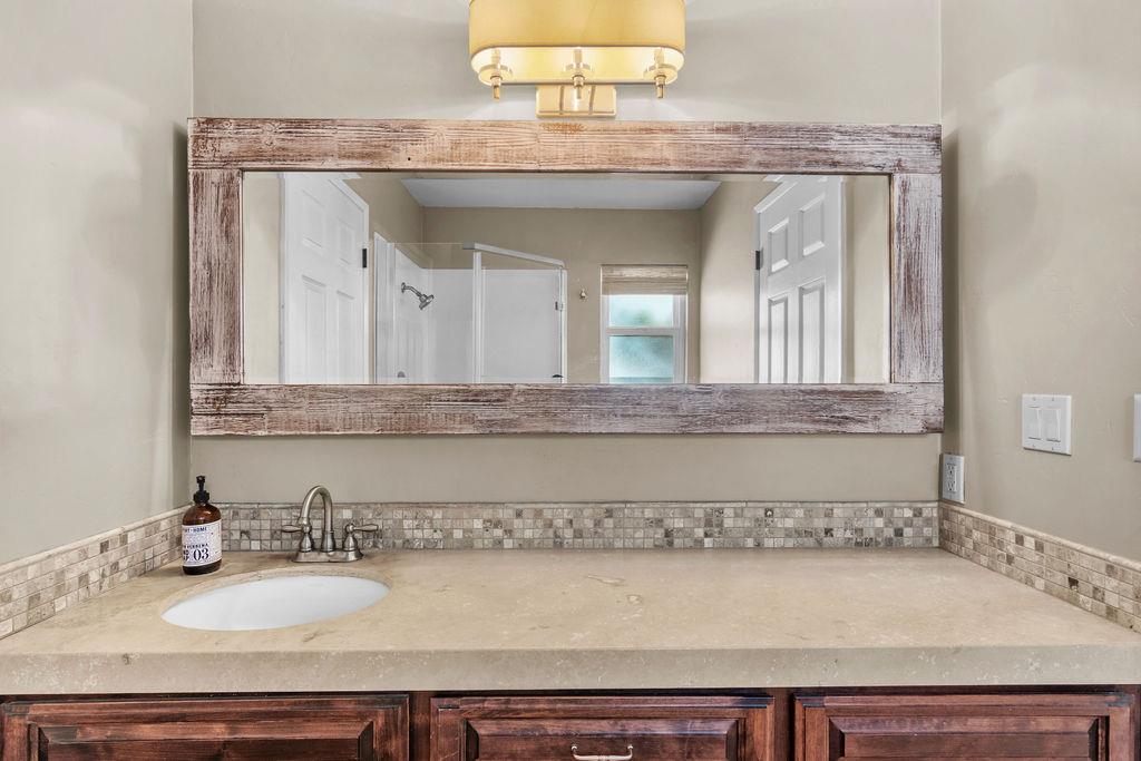 4930 South Faith Home Road Turlock, CA 95380 - Photo 25 of 69 full bathroom with vanity and a shower stall between bedroom and laundry area