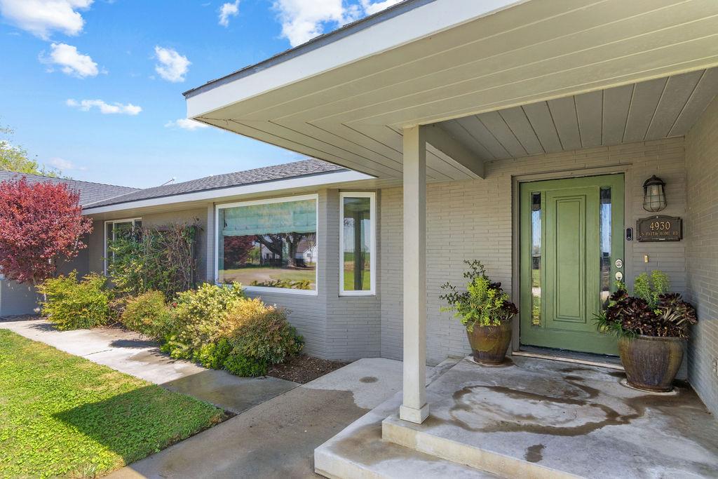 4930 South Faith Home Road Turlock, CA 95380 - Photo 3 of 69 property entrance featuring a porch, brick siding, and roof with shingles