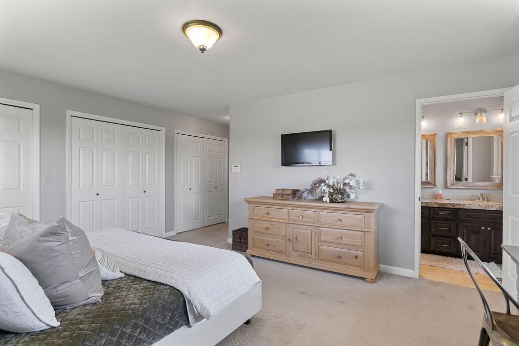 4930 South Faith Home Road Turlock, CA 95380 - Photo 38 of 69 Primary bedroom with multiple cedar closets, light colored carpet, and primary bath