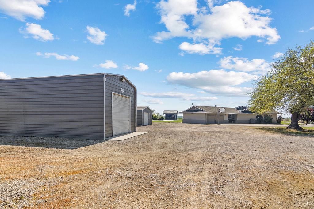 4930 South Faith Home Road Turlock, CA 95380 - Photo 57 of 69 view of yard featuring an outbuilding and a detached garage