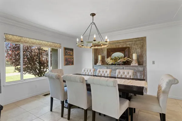 a living room with furniture a chandelier and a flat screen tv