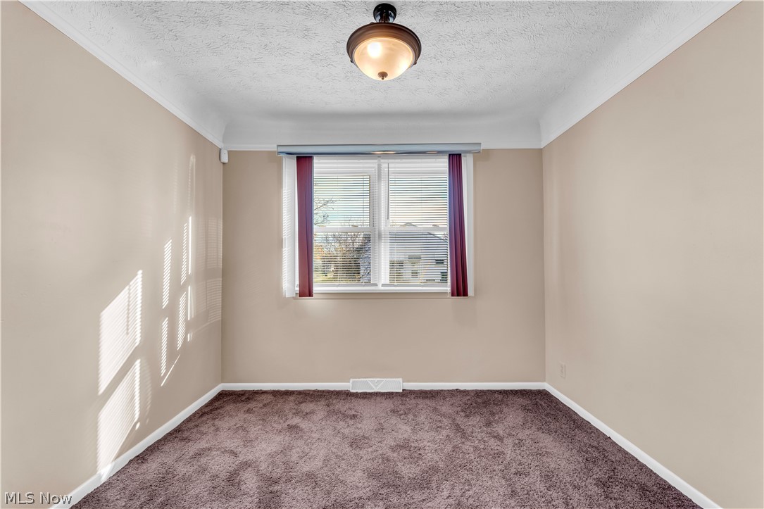 9716 Alexander Road Cleveland, OH 44125 - Photo 9 of 30 Empty room with carpet floors and a textured ceiling
