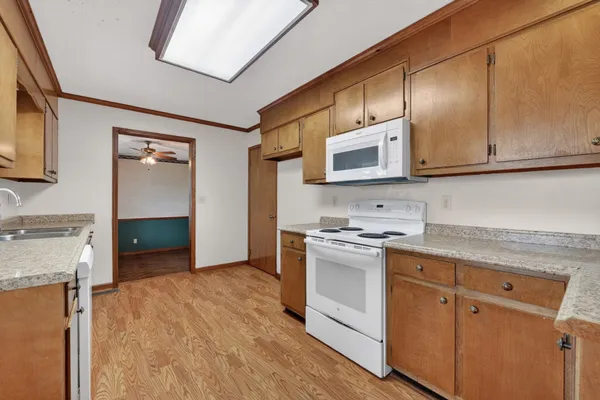 a kitchen with stainless steel appliances granite countertop a stove a sink and a microwave