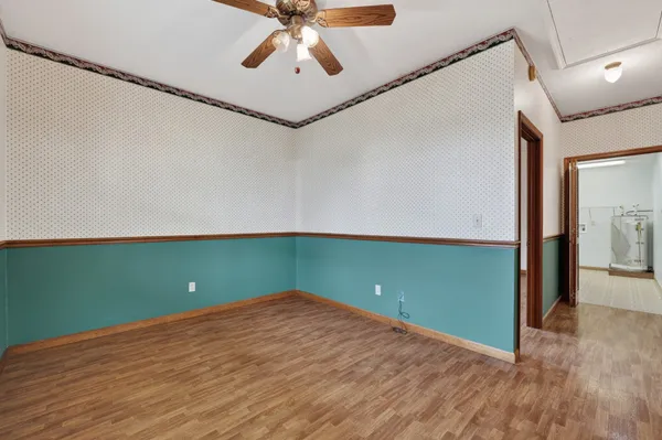 a view of a room that has a fan and wooden floor