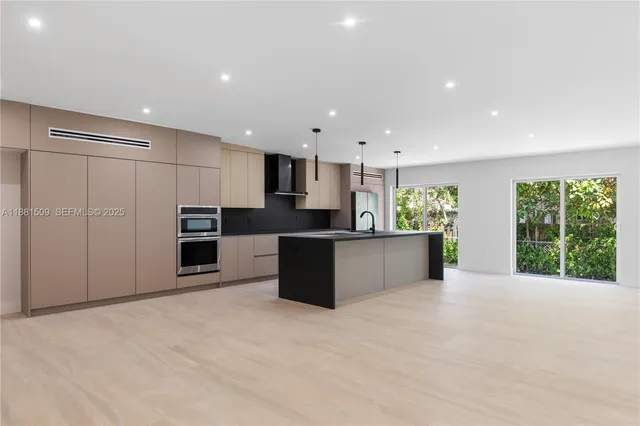 a large kitchen with a large counter top stainless steel appliances and cabinets