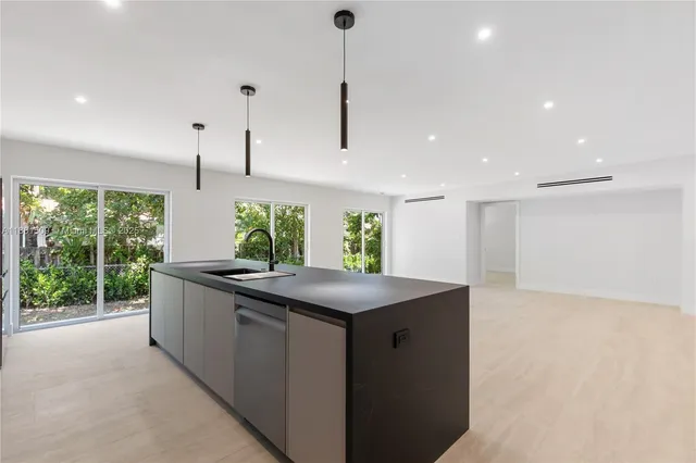 a kitchen with stainless steel appliances granite countertop a sink a counter space and a window
