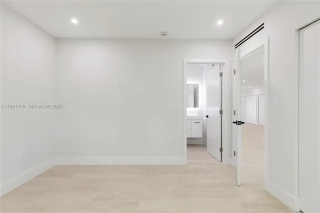 a bedroom with a bed a chair and next to a window