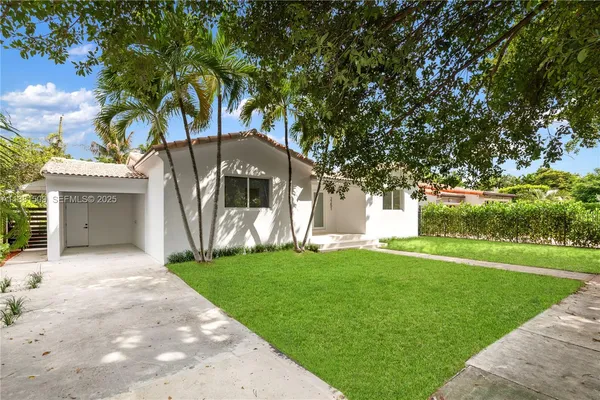 a front view of a house with a garden and yard
