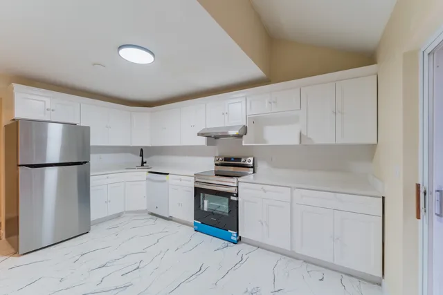 a kitchen with a stove sink and refrigerator
