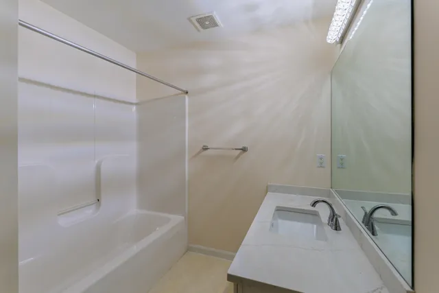 a bathroom with a sink a bathtub and shower