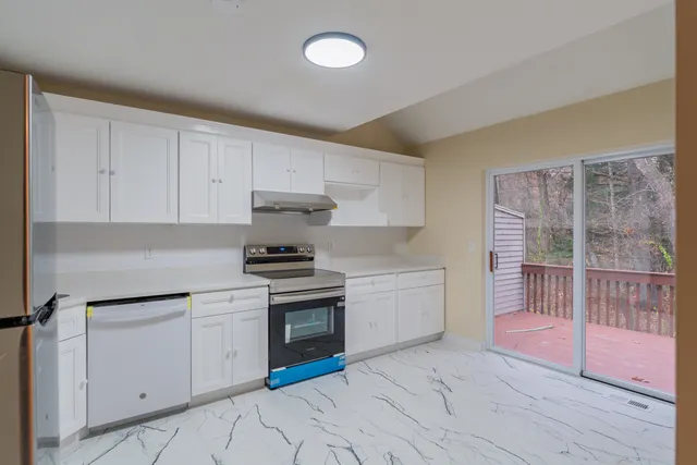 a kitchen with granite countertop a stove a sink and a cabinets