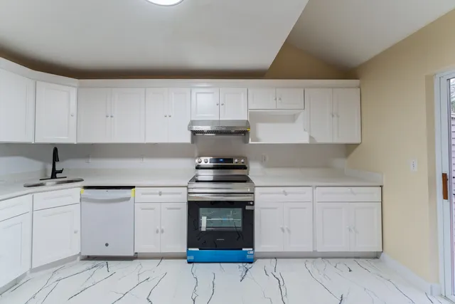 a kitchen with cabinets appliances and a sink