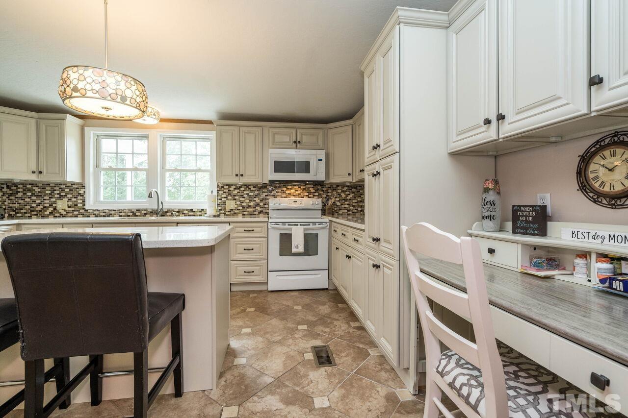 7409 Sidecreek Drive Raleigh, NC 27610 - Photo 11 of 29 a kitchen with stainless steel appliances granite countertop a sink and cabinets