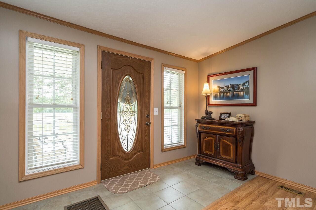 7409 Sidecreek Drive Raleigh, NC 27610 - Photo 4 of 29 a view of front door with wooden floor