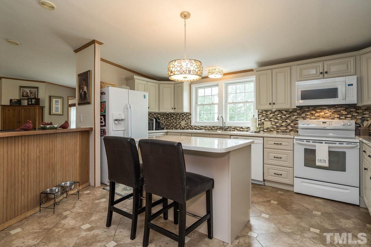 7409 Sidecreek Drive Raleigh, NC 27610 - Photo 10 of 29 a kitchen with cabinets a sink stainless steel appliances and window