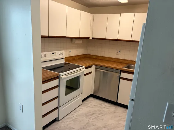 a kitchen with white cabinets and white appliances