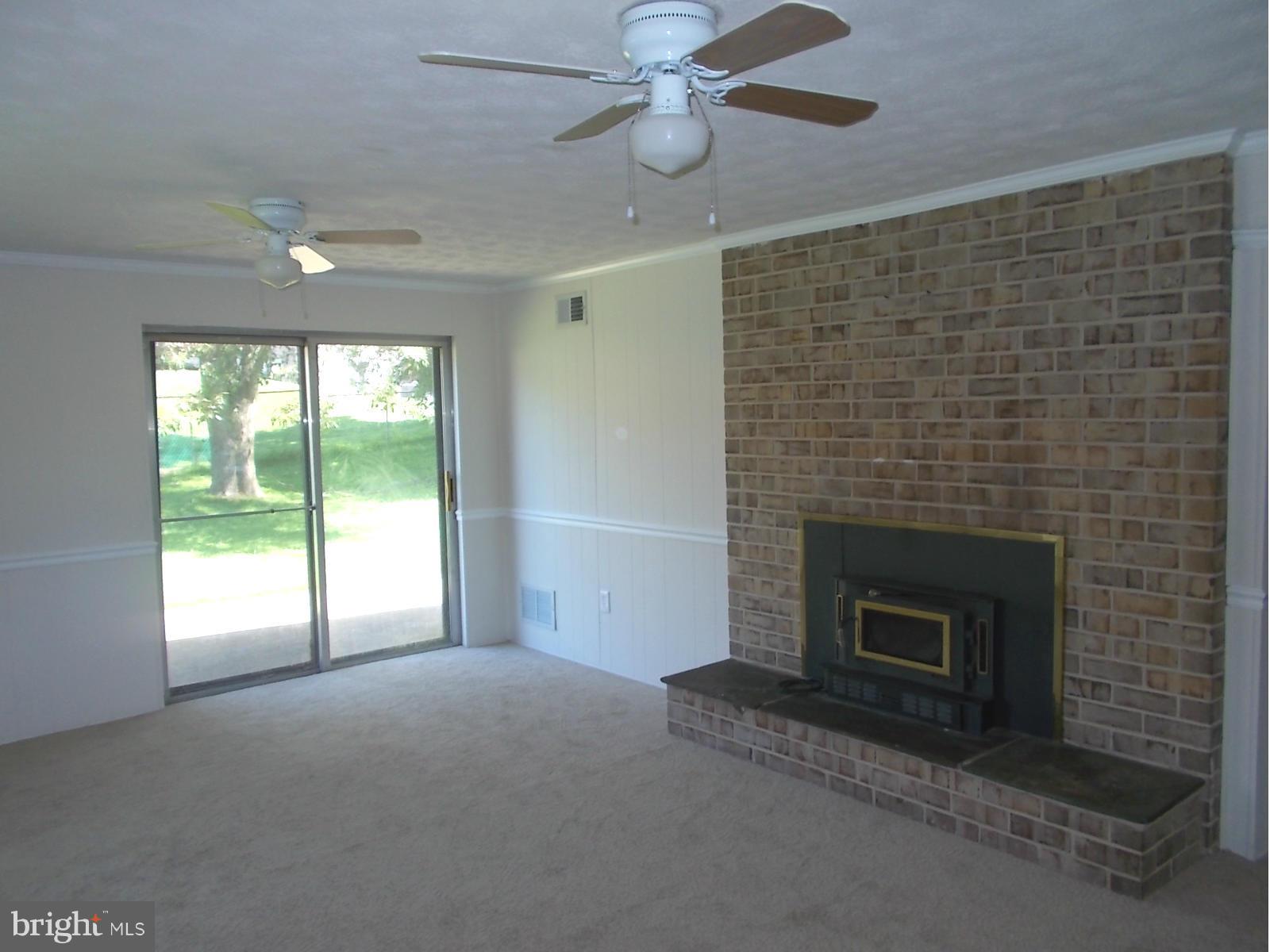 3529 Falling Green Road Olney, MD 20832 - Photo 15 of 16 a living room with a fireplace and a ceiling fan