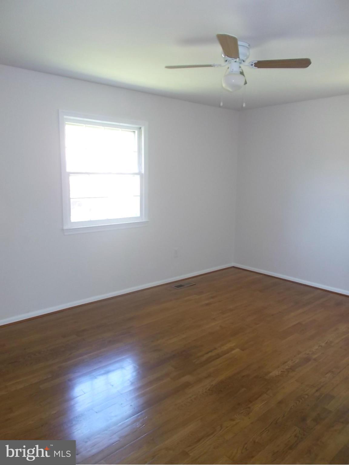 3529 Falling Green Road Olney, MD 20832 - Photo 9 of 16 an empty room with wooden floor fan and windows