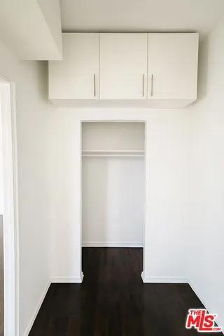 a view of small space with wooden floor and cabinets