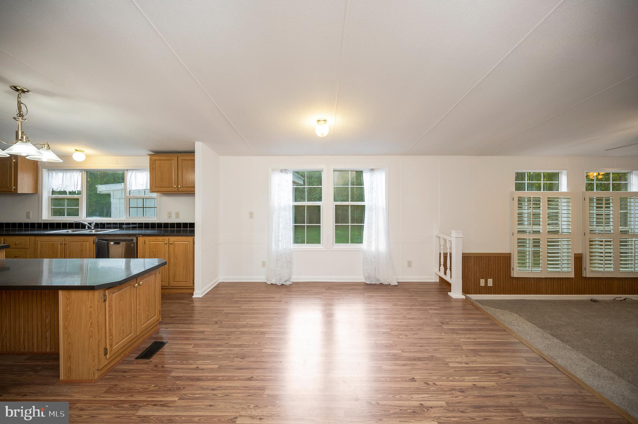 9863 Red Hill Road Spotsylvania, VA 22553 - Photo 13 of 53 a view of a kitchen with kitchen island a sink wooden floor and a large window
