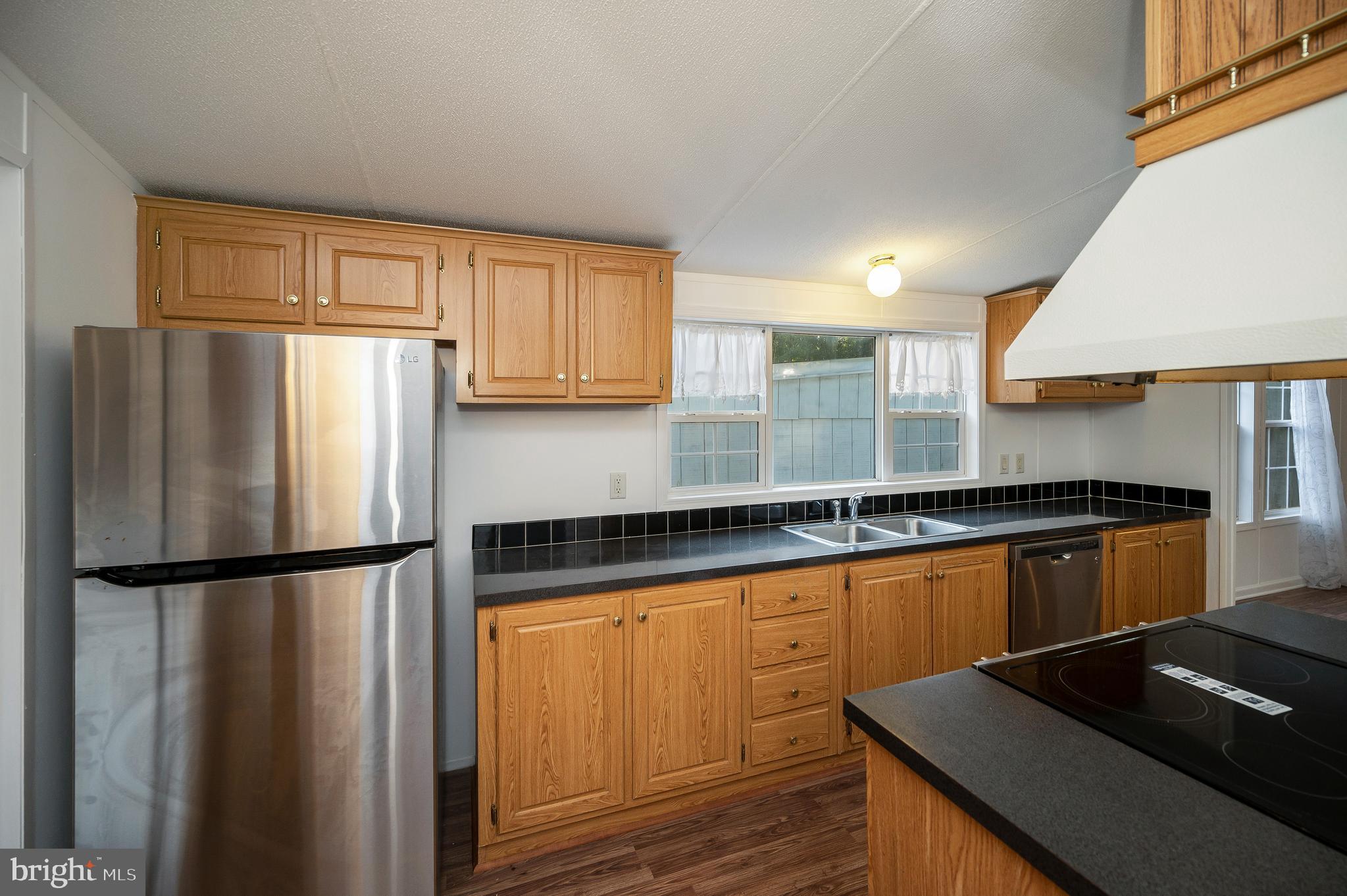 9863 Red Hill Road Spotsylvania, VA 22553 - Photo 20 of 53 a kitchen with granite countertop a refrigerator and a sink