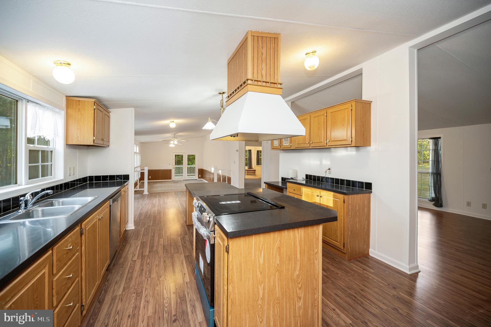 9863 Red Hill Road Spotsylvania, VA 22553 - Photo 21 of 53 a kitchen with stainless steel appliances granite countertop a sink a stove and a wooden floors