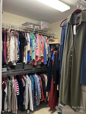 a view of walk in closet with clothes and shoes