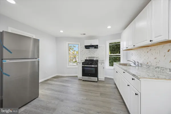 a kitchen with granite countertop a refrigerator and a sink