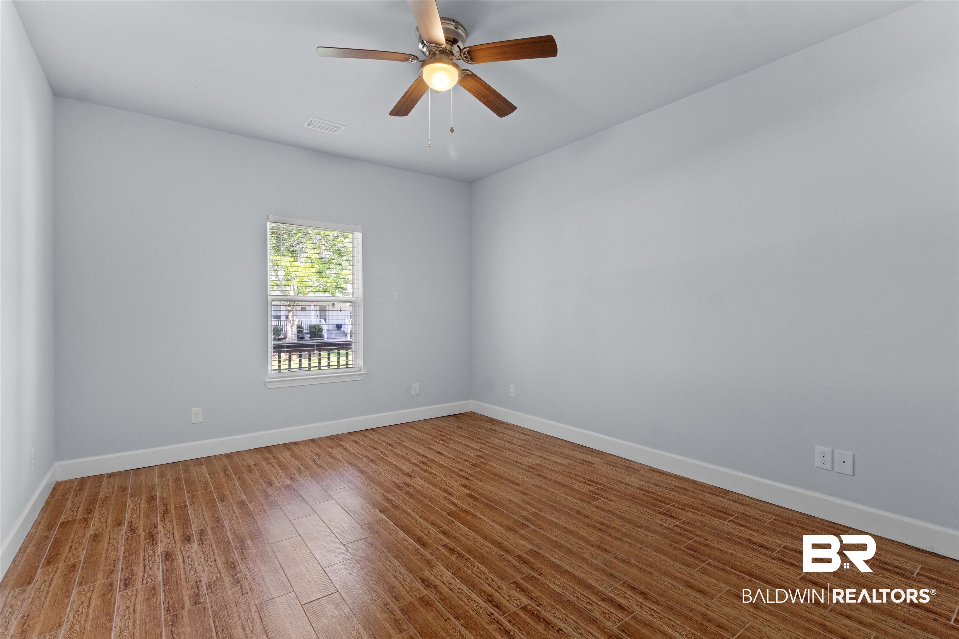 927 Periwinkle Lane Foley, AL 36535 - Photo 12 of 26 Room featuring a ceiling fan with light fixture, wood-finish flooring, and white baseboards