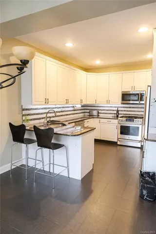 a kitchen with stainless steel appliances granite countertop a stove a sink and a refrigerator