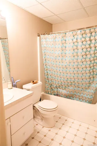 a bathroom with a granite countertop toilet a sink and a mirror